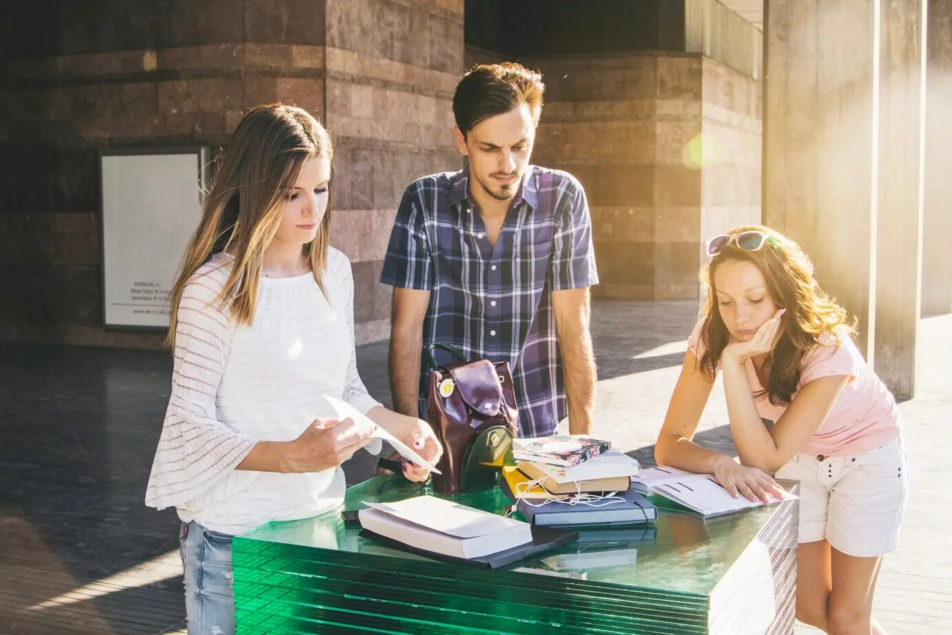 Jugendliche posieren draußen mit Büchern.