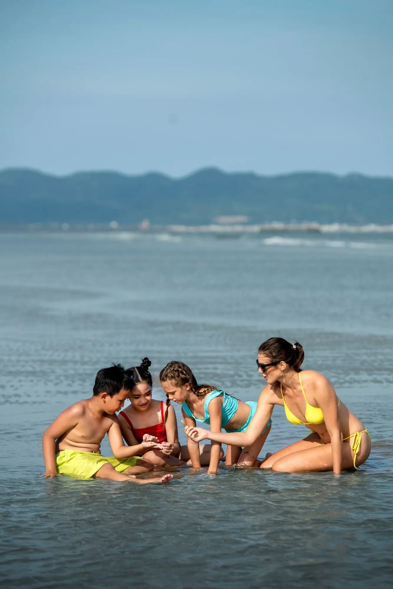 Ganzkörperaufnahme von einer Frau und Kindern im Meer